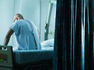 A patient sits up in his hospital bed