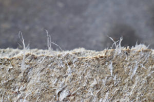 A closeup shot of beige and grey asbestos fibers.