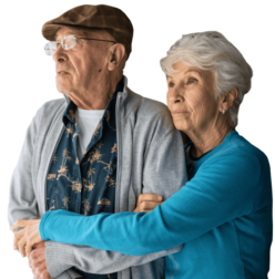 An older man and his wife hold each other.