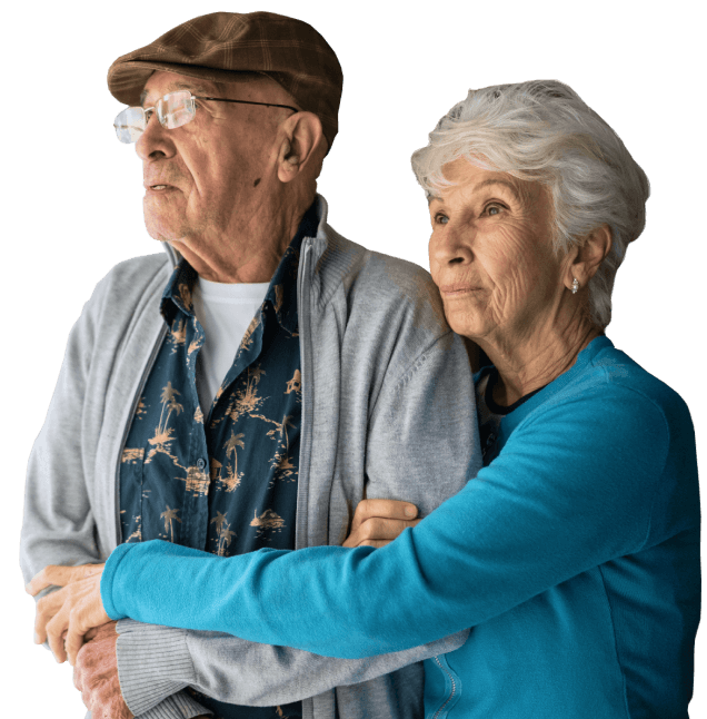 An older man and his wife hold each other.