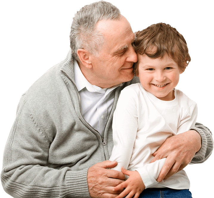 A grandfather hugs his grandson. Both are smiling.