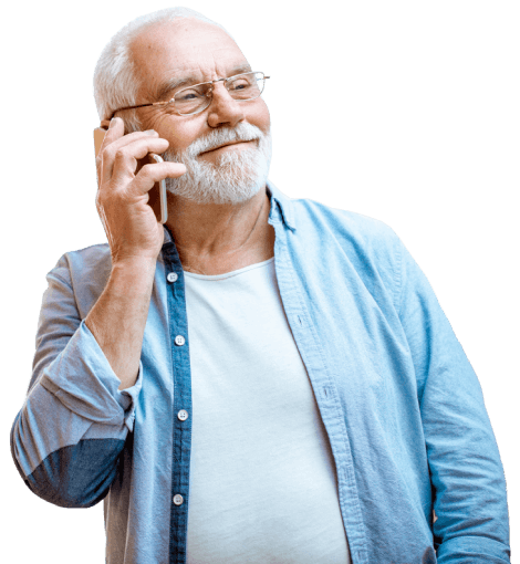 An older male in a blue shirt talks on the phone.