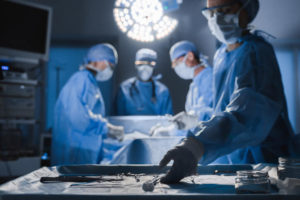 A group of doctors in blue scrubs performing surgery in a hospital