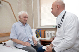 A male doctor meets with an older male patients