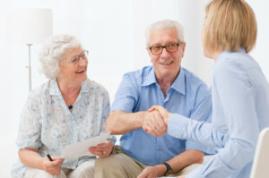 Elderly couple shakes hands with lawyer