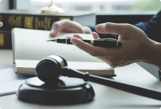 closeup of a lawyer at a desk with a gavel and notebook
