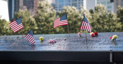 Several American flags on a memorial plaque