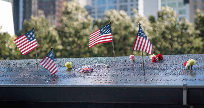 Several American flags on a memorial plaque